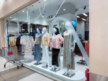 Rawang, Selangor, Malezya - 27 Kasım 2025 - Bir alışveriş merkezinin vitrininde kadın kıyafetleri sergileyen mankenler.