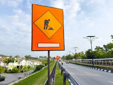 Yol boyunca sürücülere yol çalışması ve ihtiyatı gösteren bir inşaat işçisi sembolü gösteren bir tabela..