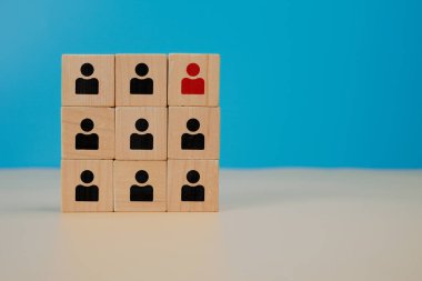 İnsan kaynakları ve takım seçimi konsepti. Mavi arka planda seçilmiş bir kişinin altını çizen tahta küpler işe alma, liderlik, yetenek yönetimi ve karar verme mekanizmasını temsil ediyor..