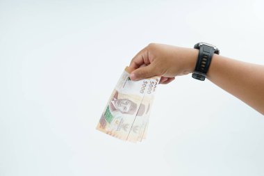 Beyaz zemin üzerinde el ele tutuşan Endonezya rupiah banknotu nakit ödeme, kişisel finans, gelir ve temiz minimum kompozisyon ile mali işlemleri temsil ediyor.