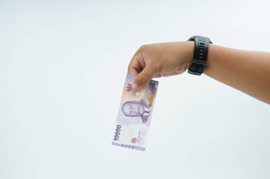 Beyaz zemin üzerinde el ele tutuşan Endonezya rupiah banknotu nakit ödeme, kişisel finans, gelir ve temiz minimum kompozisyon ile mali işlemleri temsil ediyor.