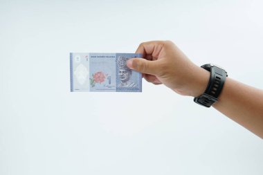 Beyaz zemin üzerinde el ele tutuşan Malezya bankası nakit ödeme, kişisel finans, gelir ve temiz minimum kompozisyon ile mali işlemleri temsil ediyor.