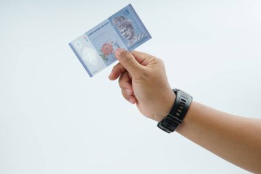 Beyaz zemin üzerinde el ele tutuşan Malezya bankası nakit ödeme, kişisel finans, gelir ve temiz minimum kompozisyon ile mali işlemleri temsil ediyor.