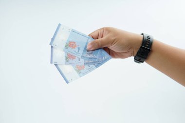 Beyaz zemin üzerinde el ele tutuşan Malezya bankası nakit ödeme, kişisel finans, gelir ve temiz minimum kompozisyon ile mali işlemleri temsil ediyor.