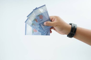 Beyaz zemin üzerinde el ele tutuşan Malezya bankası nakit ödeme, kişisel finans, gelir ve temiz minimum kompozisyon ile mali işlemleri temsil ediyor.