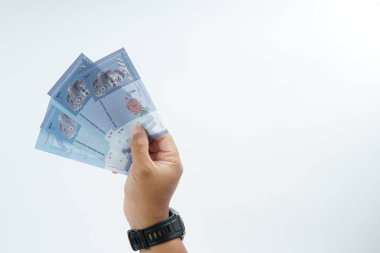 Beyaz zemin üzerinde el ele tutuşan Malezya bankası nakit ödeme, kişisel finans, gelir ve temiz minimum kompozisyon ile mali işlemleri temsil ediyor.