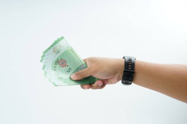 Beyaz zemin üzerinde el ele tutuşan Malezya bankası nakit ödeme, kişisel finans, gelir ve temiz minimum kompozisyon ile mali işlemleri temsil ediyor.