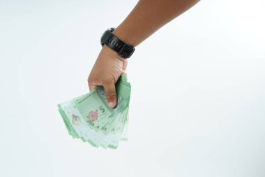 Beyaz zemin üzerinde el ele tutuşan Malezya bankası nakit ödeme, kişisel finans, gelir ve temiz minimum kompozisyon ile mali işlemleri temsil ediyor.