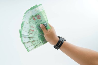 Beyaz zemin üzerinde el ele tutuşan Malezya bankası nakit ödeme, kişisel finans, gelir ve temiz minimum kompozisyon ile mali işlemleri temsil ediyor.