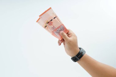 Beyaz zemin üzerinde el ele tutuşan Malezya bankası nakit ödeme, kişisel finans, gelir ve temiz minimum kompozisyon ile mali işlemleri temsil ediyor.