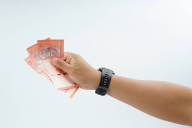 Beyaz zemin üzerinde el ele tutuşan Malezya bankası nakit ödeme, kişisel finans, gelir ve temiz minimum kompozisyon ile mali işlemleri temsil ediyor.