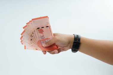 Beyaz zemin üzerinde el ele tutuşan Malezya bankası nakit ödeme, kişisel finans, gelir ve temiz minimum kompozisyon ile mali işlemleri temsil ediyor.