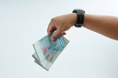 Beyaz zemin üzerinde el ele tutuşan Malezya bankası nakit ödeme, kişisel finans, gelir ve temiz minimum kompozisyon ile mali işlemleri temsil ediyor.