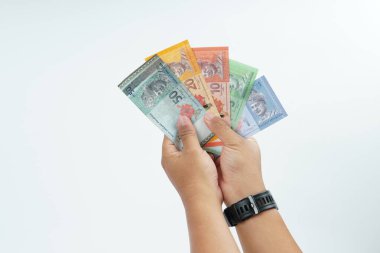 Beyaz zemin üzerinde el ele tutuşan Malezya bankası nakit ödeme, kişisel finans, gelir ve temiz minimum kompozisyon ile mali işlemleri temsil ediyor.