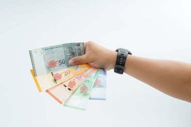 Beyaz zemin üzerinde el ele tutuşan Malezya bankası nakit ödeme, kişisel finans, gelir ve temiz minimum kompozisyon ile mali işlemleri temsil ediyor.