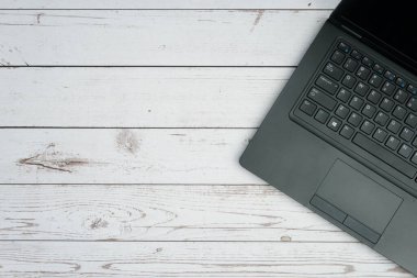 Verimliliği, uzaktan çalışmayı, dijital ofis ortamını ve kopyalama alanı olan profesyonel minimalist yapıyı temsil eden beyaz ahşap masa üzerinde dizüstü bilgisayarı olan modern iş alanı.