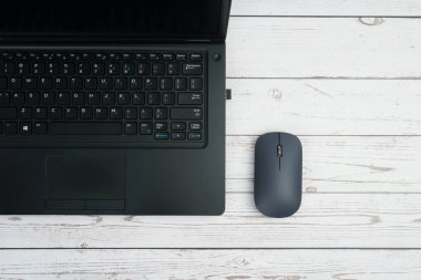 Verimliliği, dijital çalışmayı, ofis ortamını ve temiz kopya alanı olan profesyonel kurulumu temsil eden beyaz ahşap masa üzerinde dizüstü bilgisayarı ve faresi olan modern iş alanı.