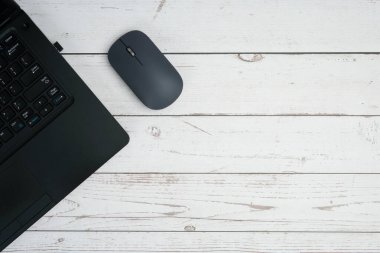 Verimliliği, dijital çalışmayı, ofis ortamını ve temiz kopya alanı olan profesyonel kurulumu temsil eden beyaz ahşap masa üzerinde dizüstü bilgisayarı ve faresi olan modern iş alanı.