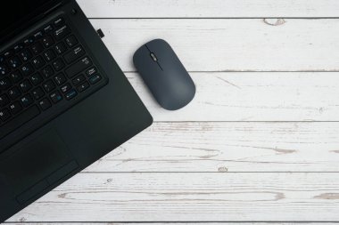 Verimliliği, dijital çalışmayı, ofis ortamını ve temiz kopya alanı olan profesyonel kurulumu temsil eden beyaz ahşap masa üzerinde dizüstü bilgisayarı ve faresi olan modern iş alanı.