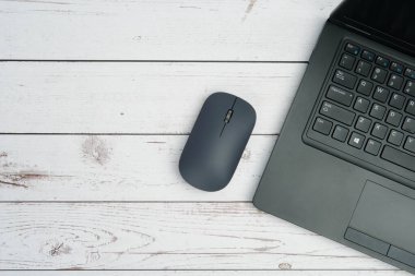 Verimliliği, dijital çalışmayı, ofis ortamını ve temiz kopya alanı olan profesyonel kurulumu temsil eden beyaz ahşap masa üzerinde dizüstü bilgisayarı ve faresi olan modern iş alanı.