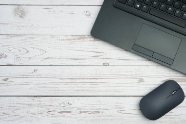 Verimliliği, dijital çalışmayı, ofis ortamını ve temiz kopya alanı olan profesyonel kurulumu temsil eden beyaz ahşap masa üzerinde dizüstü bilgisayarı ve faresi olan modern iş alanı.