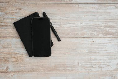 Planlama, yazma, iş notlarını, üretkenlik, organizasyon, asgari çalışma alanı ve kopyalama alanını temsil eden beyaz ahşap arkaplan üzerine düz bir defter ve kalem..