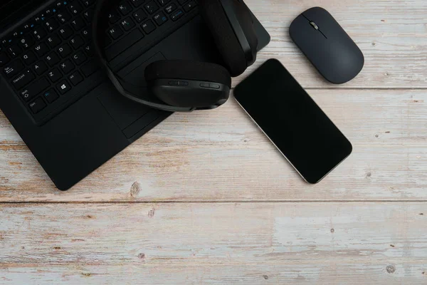 Bilgisayarlı, akıllı telefonlu, fareli, kulaklıklı ve beyaz ahşap masadaki kahve ile en üst düzey çalışma alanı üretkenliği, uzaktan çalışmayı, dijital odağı ve temiz kopya alanı olan profesyonel ofis ortamını temsil ediyor..