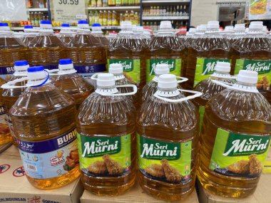 Rawang, Selangor, Malaysia - January 28, 2026 - Cooking oil bottles displayed in large containers on a supermarket shelf for household use