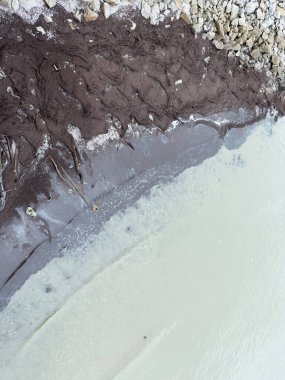 Sığ kıyı suları, küçük yeşil bitkilerle çamurlu kıyı şeridi buluşması, kırılgan kıyı ekosistemini, doğal dokuları, çevresel dengeyi ve sulak araziyi temsil ediyor..