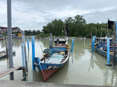 Geleneksel balıkçı tekneleri, yerel balıkçıları, deniz kültürünü, küçük ölçekli balıkçılık endüstrisini ve Asya kıyı yaşamını temsil eden Malezya 'daki bir kıyı iskelesine demirlediler..