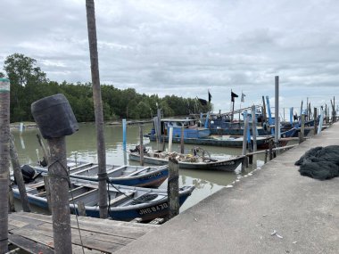 Geleneksel balıkçı tekneleri, yerel balıkçıları, deniz kültürünü, küçük ölçekli balıkçılık endüstrisini ve Asya kıyı yaşamını temsil eden Malezya 'daki bir kıyı iskelesine demirlediler..