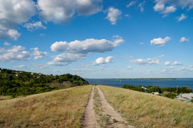 Volga Nehri 'nin arkasındaki tepeden geçen yol ve bulutlu gökyüzü. Güzel hava ve vahşi yaşam. Kalın bulutlar.