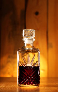 a decanter full of alcohol on a background of wooden boards