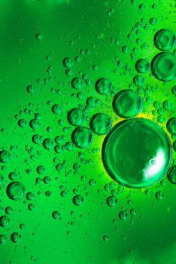 Sarı arkaplan üzerinde renkli yağ kabarcıkları