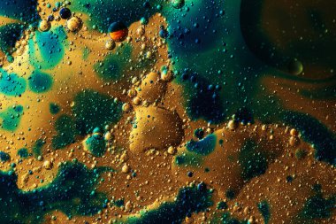 Sarı arkaplan üzerinde renkli yağ kabarcıkları