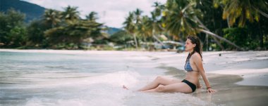 Mayolu güzel bir kadın sahilde sabah egzersizi yapıyor. Bir kadın okyanusta yoga yapıyor. Deniz kenarındaki yogalar.