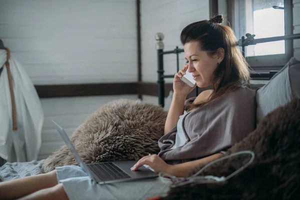 Женщина Работает Ноутбуком Телефоном Кровати Спальне Молодая Девушка Лежит Дома — стоковое фото