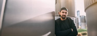 Endüstriyel geçmişi olan bir adam. Metal boruların geometrik arka planında metropoliste genç bir adam. İnsan ve büyük bir şehir