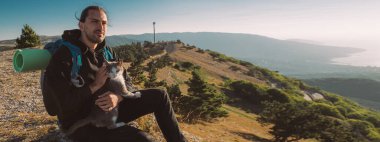 Bir erkek turist dağlarda şafakla tanışır. Yürüyüş. Genç yakışıklı bir adam sabah dağın tepesine tırmandı ve arkadaşı kedisiyle birlikte bir uçurumun kenarında oturdu. Kedi şafak vakti bir adamla dağlarda gezer.