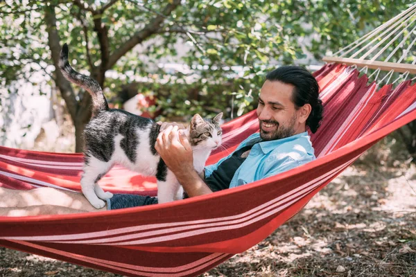 Joven Está Descansando Acariciando Gato Una Hamaca Jardín Chico Guapo —  Fotos de Stock
