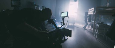 Görüntü yönetmeni elinde kamerayla sette. Bir film, ticari ya da televizyon dizisi çekmek için çalışan profesyonel bir videograf. İçerideki çekim süreci, stüdyo.