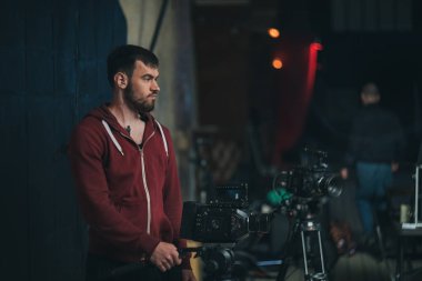 Görüntü yönetmeni elinde kamerayla sette. Bir film, ticari ya da televizyon dizisi çekmek için çalışan profesyonel bir videograf. İçerideki çekim süreci, stüdyo.