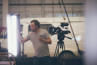 Görüntü yönetmeni elinde kamerayla sette. Bir film, ticari ya da televizyon dizisi çekmek için çalışan profesyonel bir videograf. İçerideki çekim süreci, stüdyo.