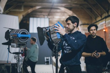 Işıklandırma ekipmanlı aydınlatma cihazları sette. Film çekmek, reklam yapmak, TV dizisi için ışıklandırma. Modern fotoğrafçılık tekniği.