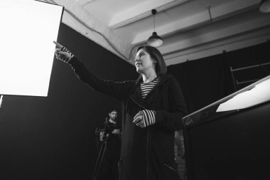 Yönetmen sette çalışıyor. Yönetmen, bir film, reklam ya da televizyon dizisi çekerken bir grupla ya da bir playback ile çalışır. Atış vardiyası, ekipman ve grup. Modern fotoğrafçılık tekniği.