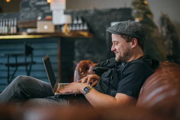 Een Man Met Een Laptop Werkt Bank Een Jonge Stijlvolle — Stockfoto