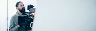 Görüntü yönetmeni elinde kamerayla sette. Bir film, ticari ya da televizyon dizisi çekmek için çalışan profesyonel bir videograf. İçerideki çekim süreci, stüdyo.