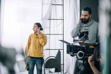 Görüntü yönetmeni elinde kamerayla sette. Bir film, ticari ya da televizyon dizisi çekmek için çalışan profesyonel bir videograf. İçerideki çekim süreci, stüdyo.