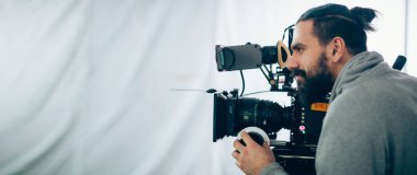 Görüntü yönetmeni elinde kamerayla sette. Bir film, ticari ya da televizyon dizisi çekmek için çalışan profesyonel bir videograf. İçerideki çekim süreci, stüdyo.