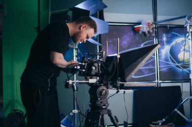 Görüntü yönetmeni elinde kamerayla sette. Bir film, ticari ya da televizyon dizisi çekmek için çalışan profesyonel bir videograf. İçerideki çekim süreci, stüdyo.